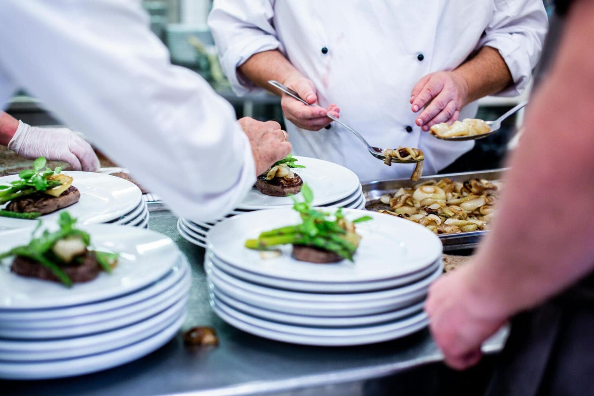 Chefs plating dishes in a professional kitchen