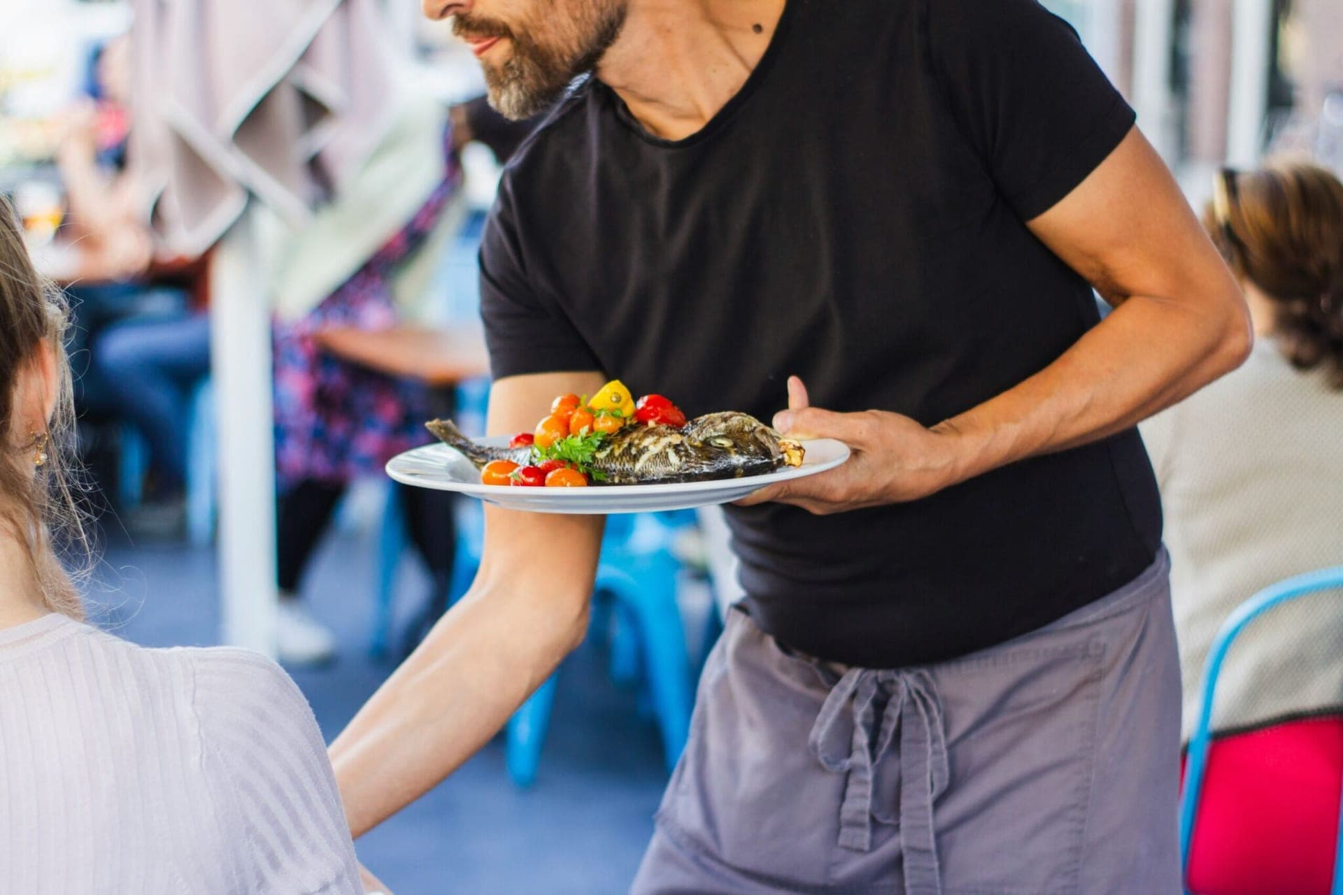 Restaurant server presenting a plated dish
